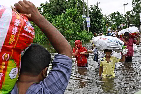 Bangladesh Floods: People walk to a relief shelter in Mohipal, Feni district
